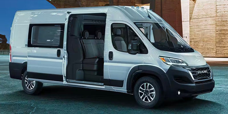 A white RAM ProMaster passenger van with the sliding door open.